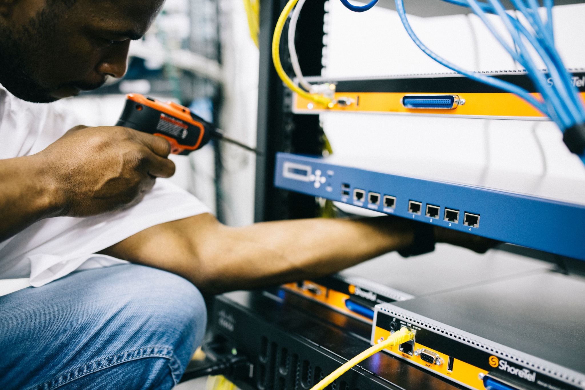 IT-Fachkraft arbeitet an Netzwerktechnik in einem Serverschrank